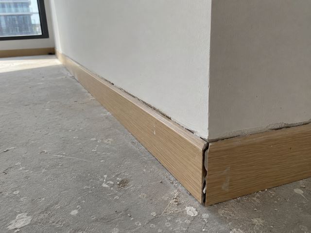 Plinthe mal ajustée dans un angle de mur